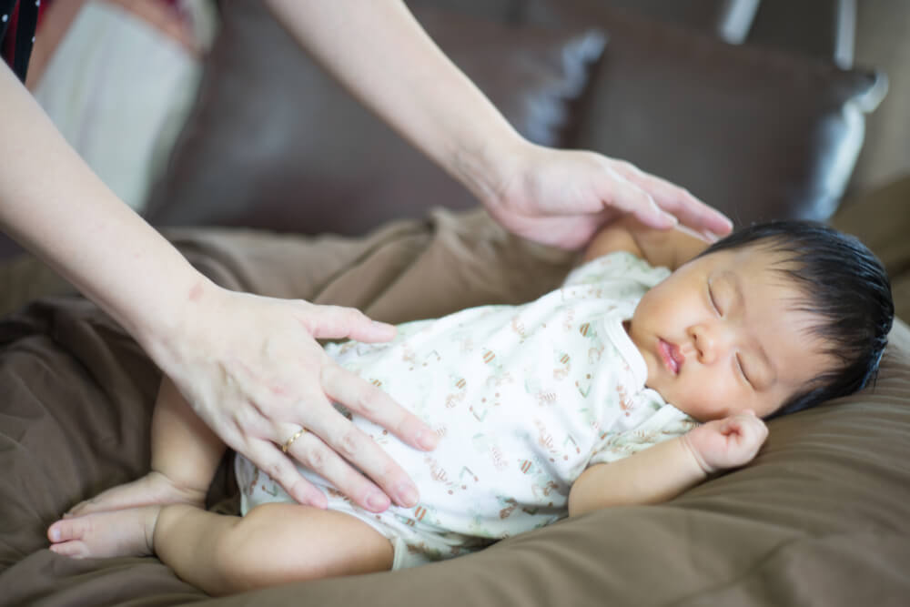 laying a baby down to support a good sleep routine