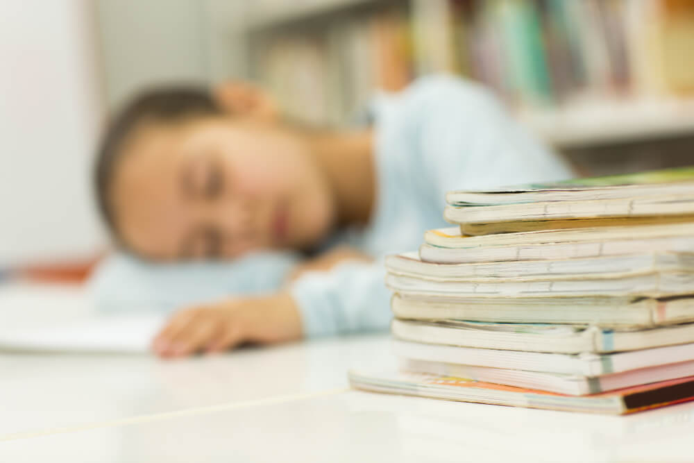 a child struggles in school and sleeps on desk
