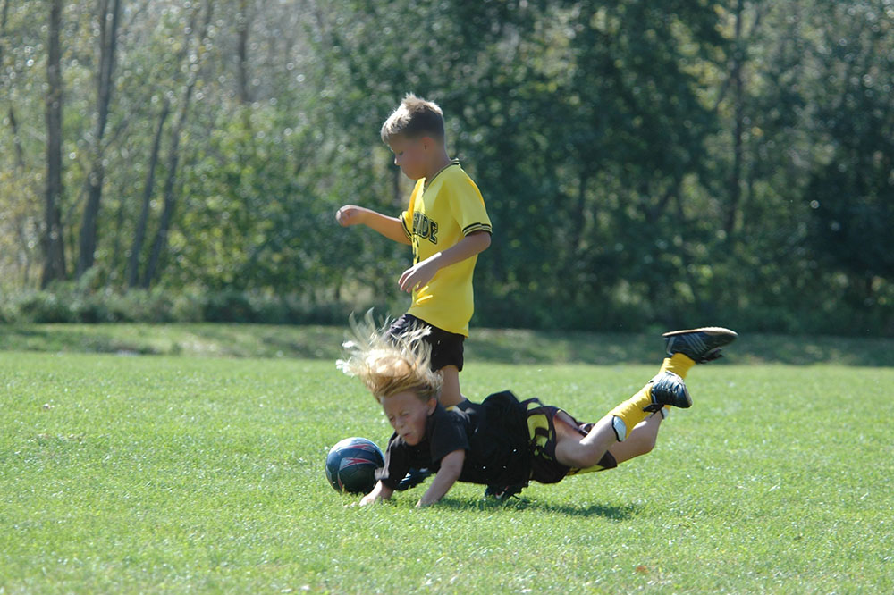 child falling while playing soccer