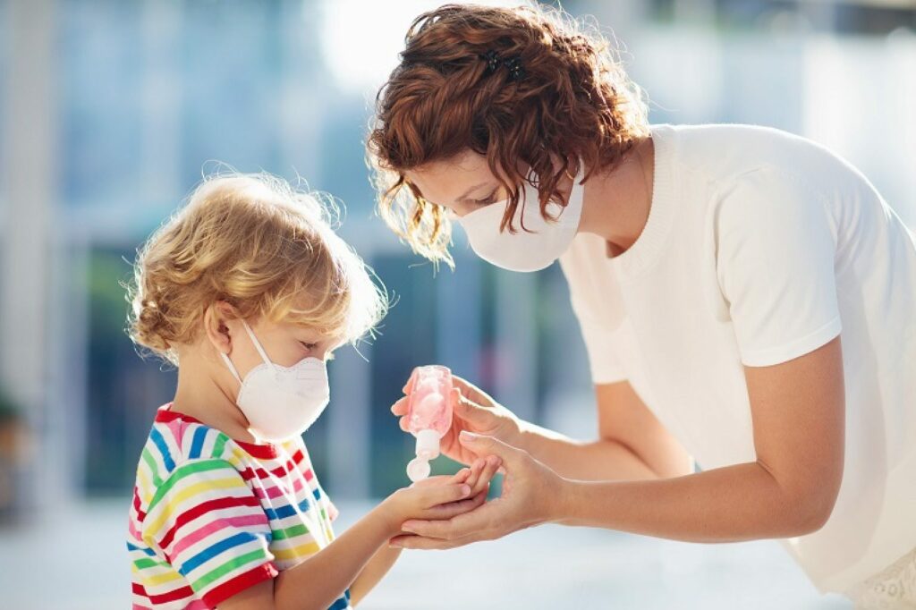 a mother sanitizing her child's hands