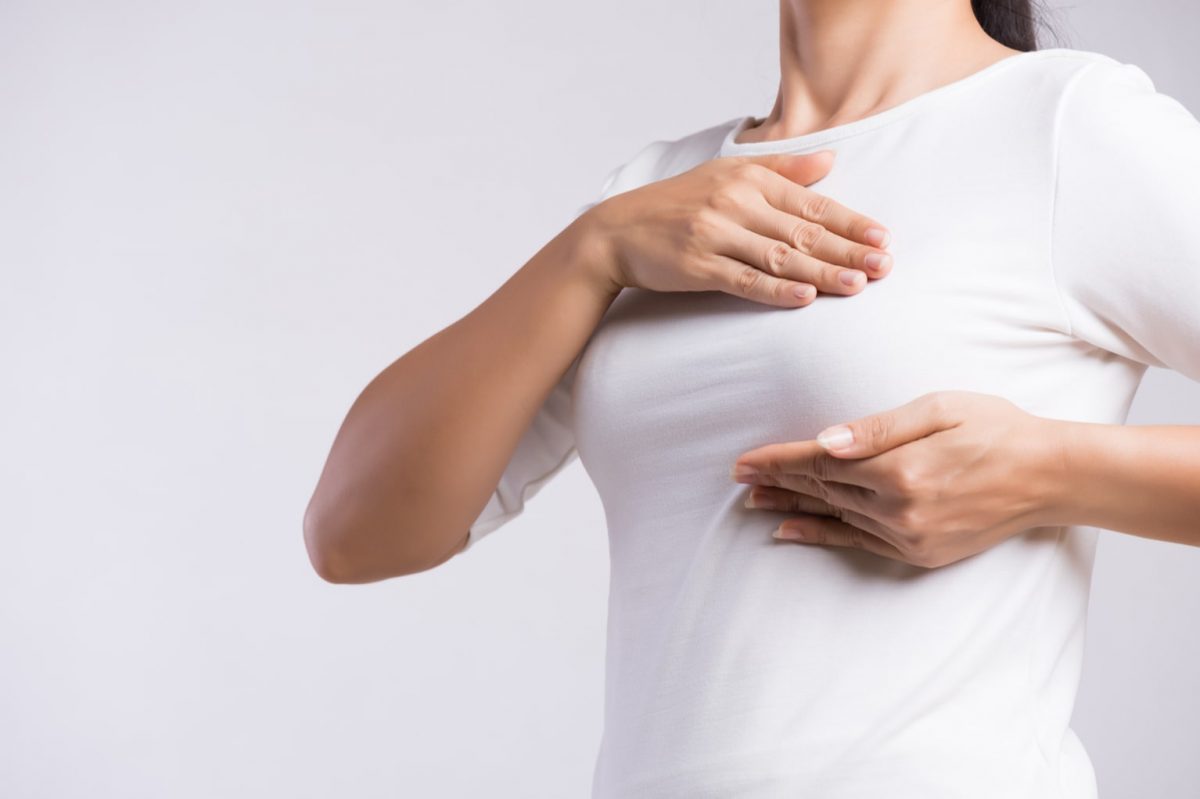 woman performing a self screening for breast cancer